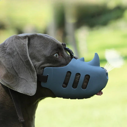 Muselière chien anti aboiement en silicone gris portée par un chien noir en extérieur
