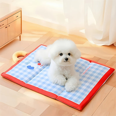 Petit chien blanc couché sur son tapis rafraichissant à carreaux roses